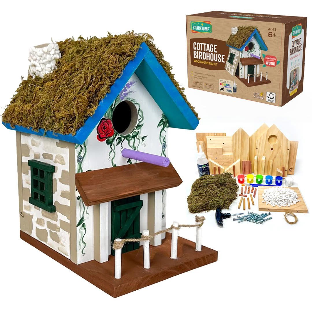 Completed SparkJump Cottage Birdhouse woodworking kit with moss roof, stone walls and blue trim
