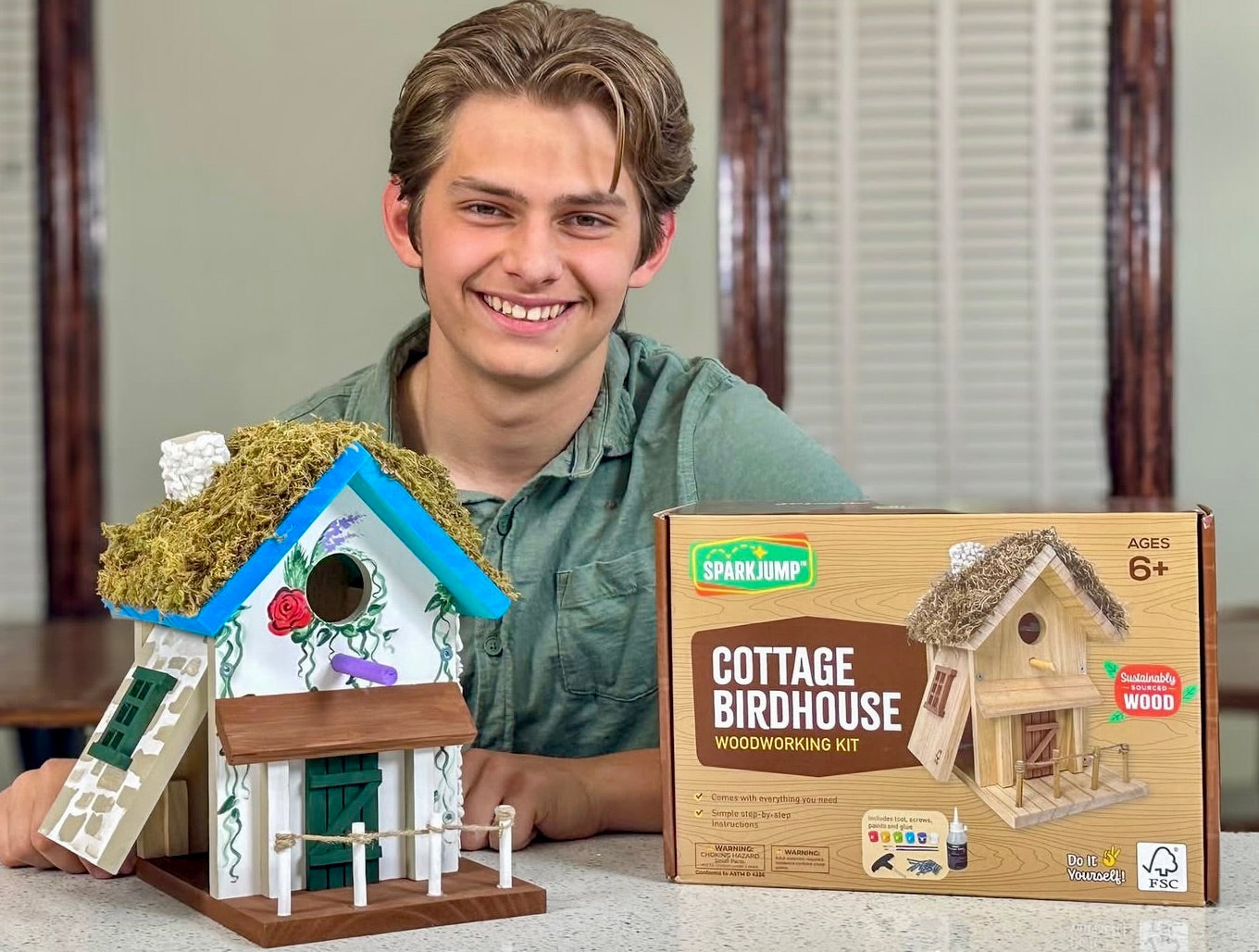 Teenager with completed Cottage Birdhouse woodworking kit and SparkJump box, ages 8 plus Australia